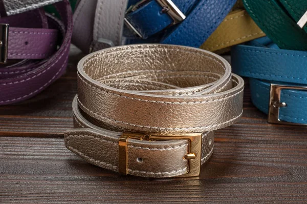 female belts on wooden surface, promoting products and demonstration of trouser belts