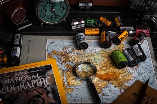 带旅游地图 照相机卷 放大镜和杂志的桌子 — 图库照片