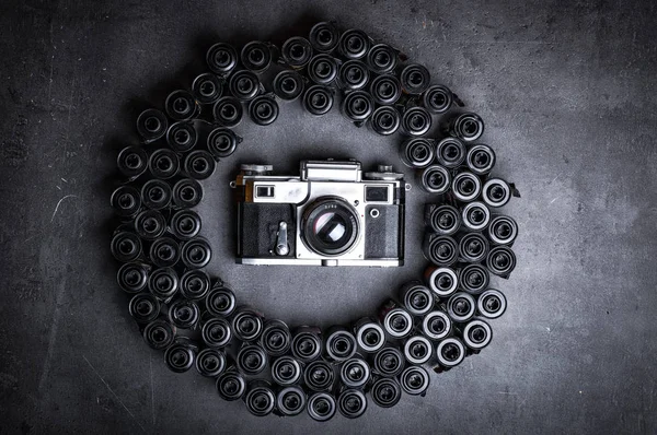 analog vintage camera with film rolls on dark surface