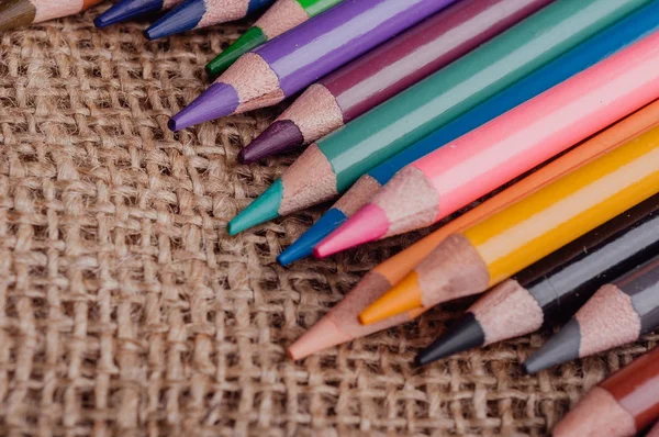 黄麻布のテクスチャ生地にカラフルな鉛筆のヒント — ストック写真