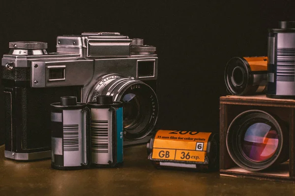 photographic vintage camera and film rolls with wooden camera lens