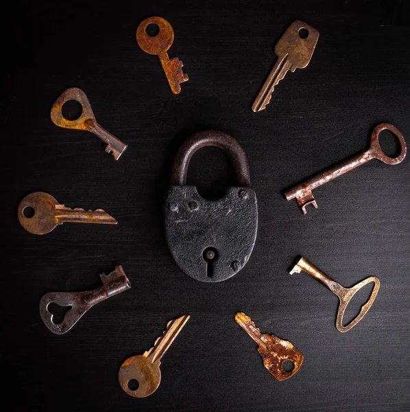 老铁挂锁中心和周围的钥匙 — 图库照片