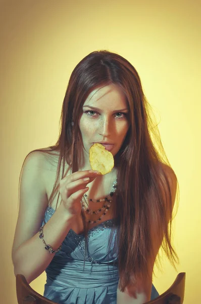 Genç kadının cipsi yemek güzel tonda stüdyo portre — Stok fotoğraf