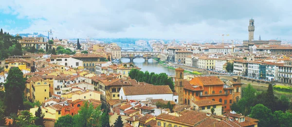 Foto panorámica de Florencia vista desde la plaza Miguel Ángel: Río Arno, Palacio Viejo, Puente Viejo y muchos tejados de ciudades edificios con cielo azul nublado —  Fotos de Stock