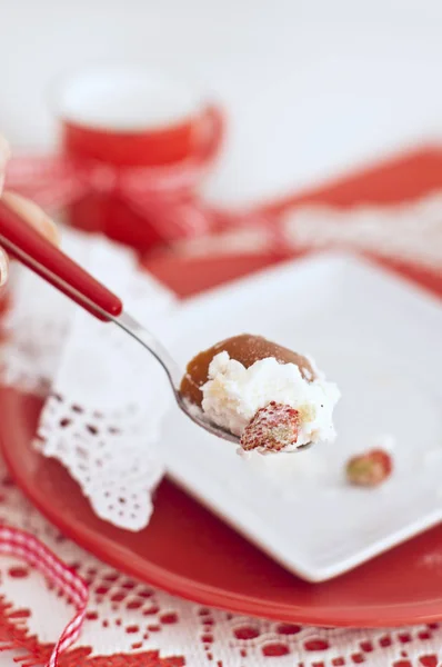 Baba con una crema y fresas en colores rojo y blanco cuchara Imágenes de stock libres de derechos