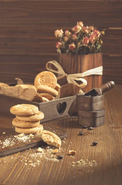 Vue latérale des biscuits ronds avec miettes et roses sèches — Photo