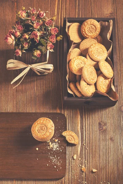 Top view of round cookies with crumbs and dry roses — Stock Photo, Image