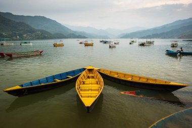 Pokhara gölde güzel gün batımı arkada ile renkli tekneler