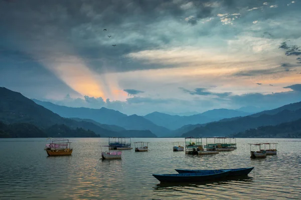 Färgglada båtar på sjön i Pokhara med vacker solnedgång i ryggen — Stockfoto