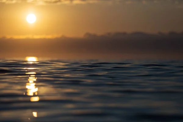 Salida del sol sobre un mar con pequeñas olas y hermosas nubes en la espalda —  Fotos de Stock