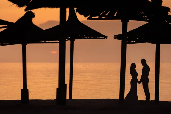 Felice coppia sposata godendo alba su una spiaggia — Foto Stock