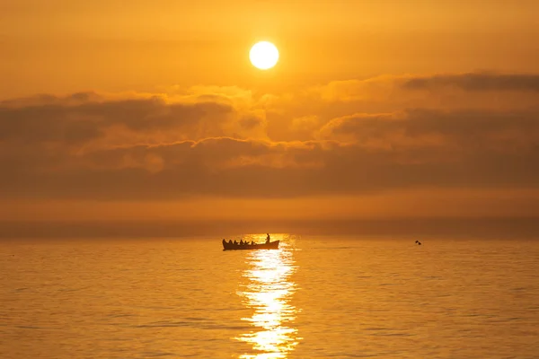 Fishermen on a boat fishing on a sea with beautiful sunrise in b — Stock Photo, Image