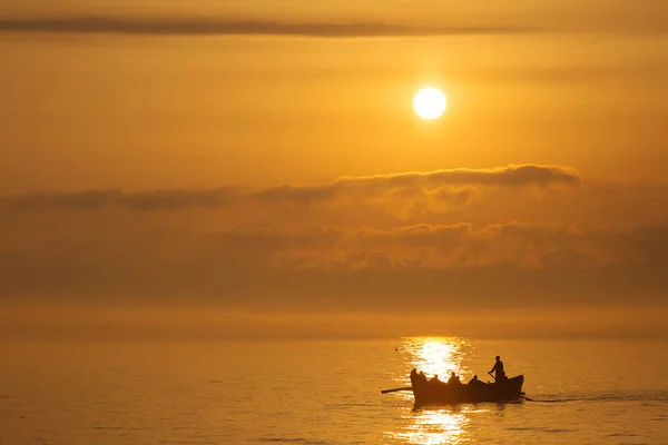 Pescadores em um barco de pesca em um mar com belo nascer do sol em b — Fotografia de Stock