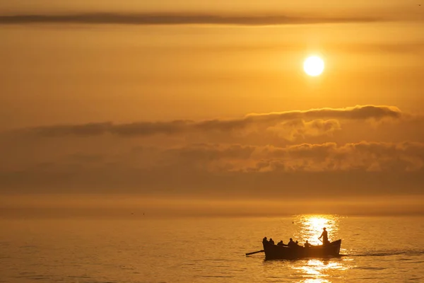 Pescadores en un barco de pesca en un mar con hermoso amanecer en b —  Fotos de Stock