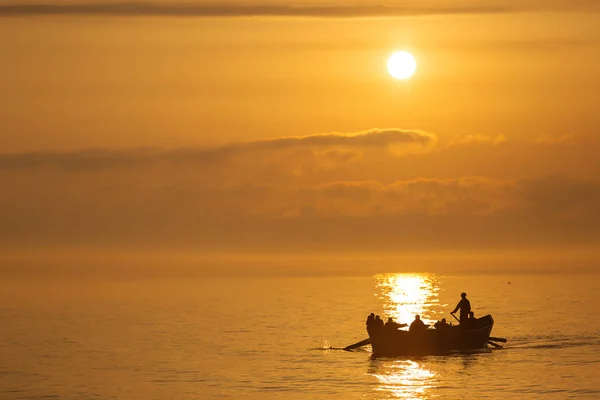 Fishermen on a boat fishing on a sea with beautiful sunrise in b — Stock Photo, Image