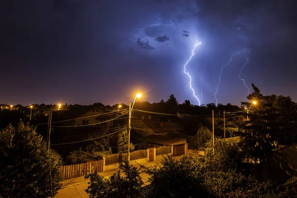 Thunder storm over houses in country side in the middle of the n — Stock Photo, Image