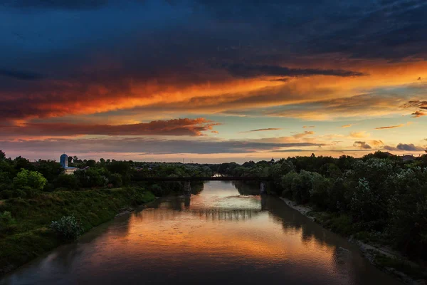 Sunset landscape over a river with beautiful colourful clouds in — Stock Photo, Image