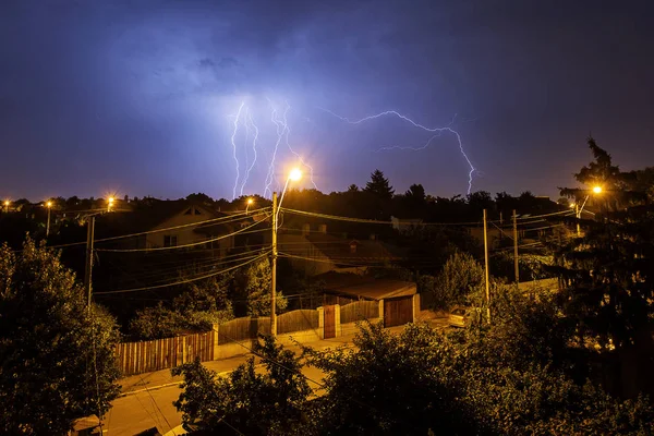 Thunder storm over houses in country side in the middle of the n