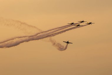 Günbatımı dumanlı arka planda uçakta silüeti