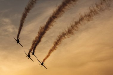 Günbatımı dumanlı arka planda uçakta silüeti