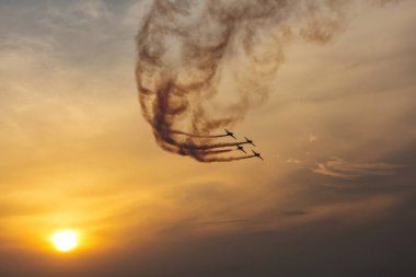 Günbatımı dumanlı arka planda uçakta silüeti