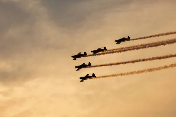 Silhouette of airplane on sunset with smoke in background — Stock Photo, Image