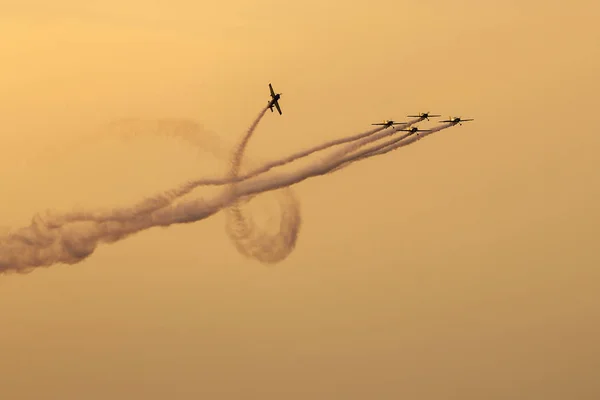 Sziluettjét repülőgép a naplemente, a háttérben a füst — Stock Fotó
