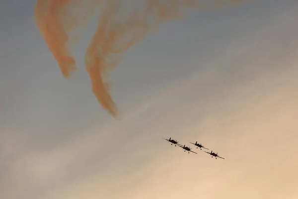 Sziluettjét repülőgép a naplemente, a háttérben a füst — Stock Fotó
