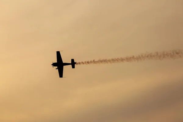 Silhouet van vliegtuig op zonsondergang met rook op achtergrond — Stockfoto