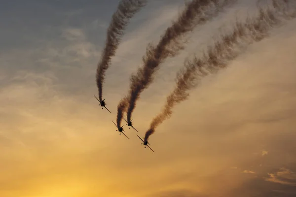 Silhouette of airplane on sunset with smoke in background — Stock Photo, Image