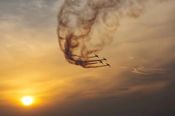 Silhouette of airplane on sunset with smoke in background — Stock Photo, Image