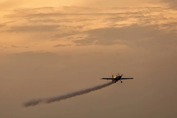 Silhouette of airplane on sunset with smoke in background — Stock Photo, Image