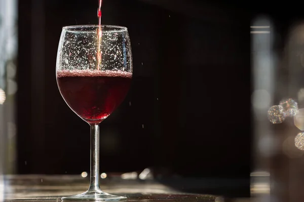 Red wine pouring into wine glass — Stock Photo, Image