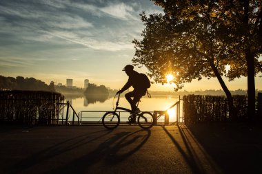 Sunrise güzel sonbahar renkleri ile bir parkta Bisiklet adam ve