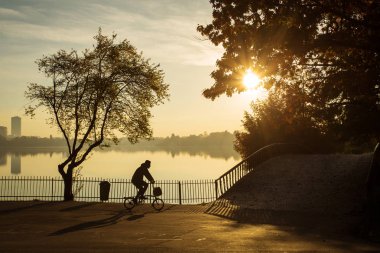 Sunrise güzel sonbahar renkleri ile bir parkta Bisiklet adam ve