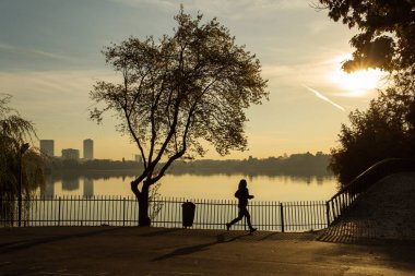 Bir parkta gündoğumu güzel sonbahar renkleri ile çalışan kadın 