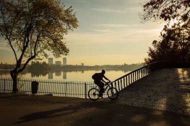Sunrise güzel sonbahar renkleri ile bir parkta Bisiklet adam ve
