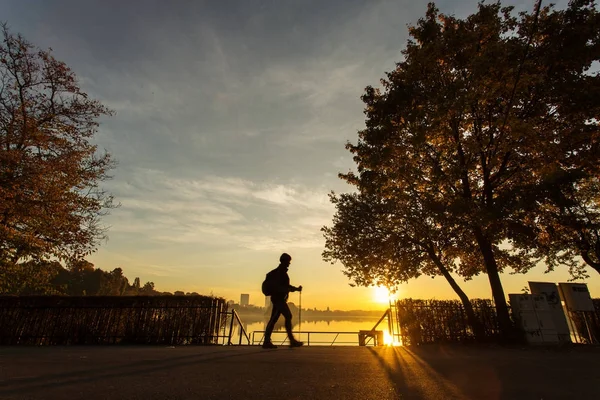 Женщина бегает в парке на рассвете с красивыми осенними красками — стоковое фото