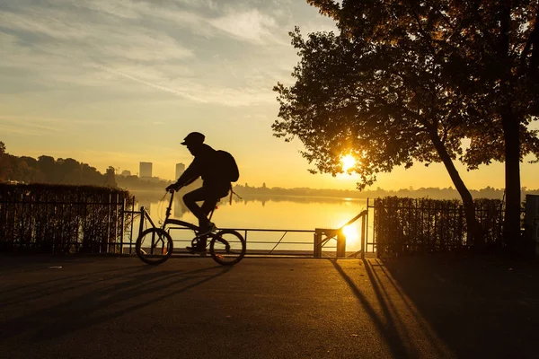 Sunrise güzel sonbahar renkleri ile bir parkta Bisiklet adam ve