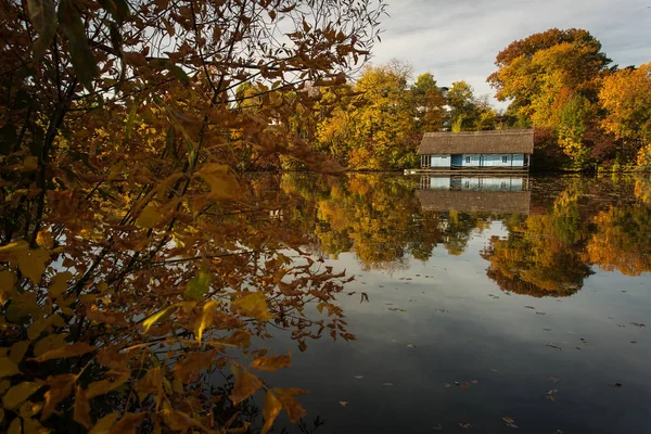 Пейзаж с красивым домом на озере с красочными листьями в — стоковое фото