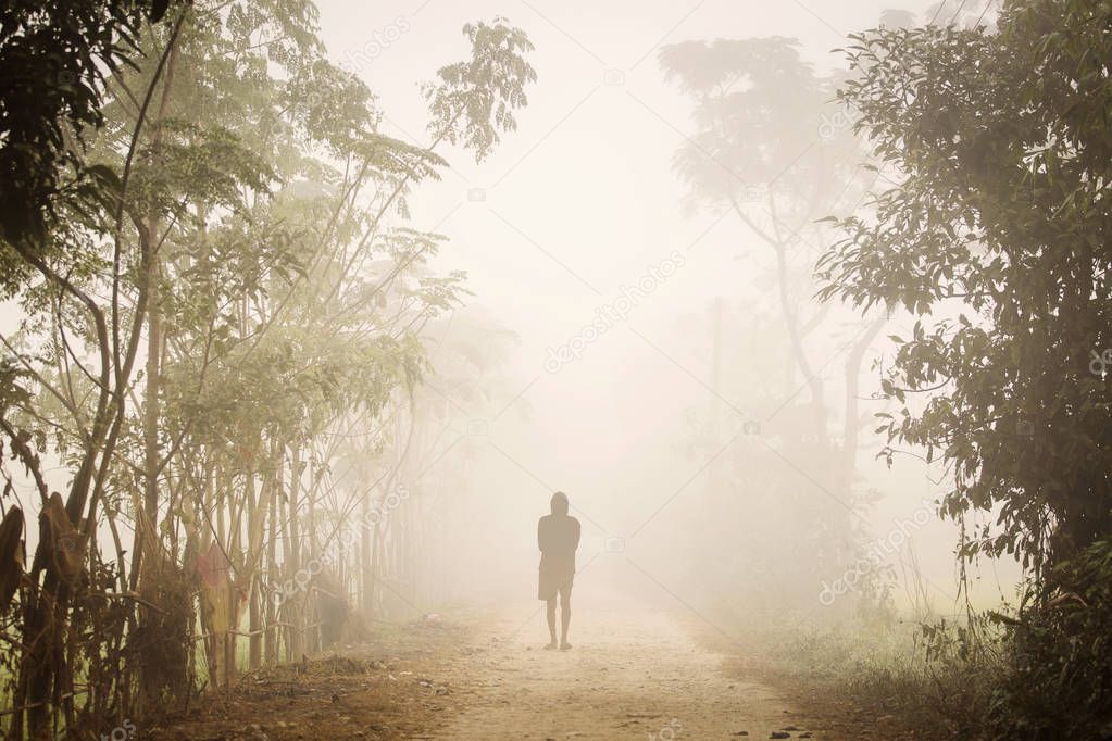 Silhouette of a man in a foggy morning in Chitwan National Park.
