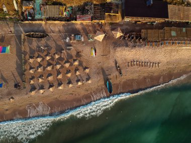 Güneşin doğuşunda şemsiyeli ve turkuaz deniz manzaralı harika bir sahil manzarası. Romanya 'nın Vama Veche kentinde Karadeniz