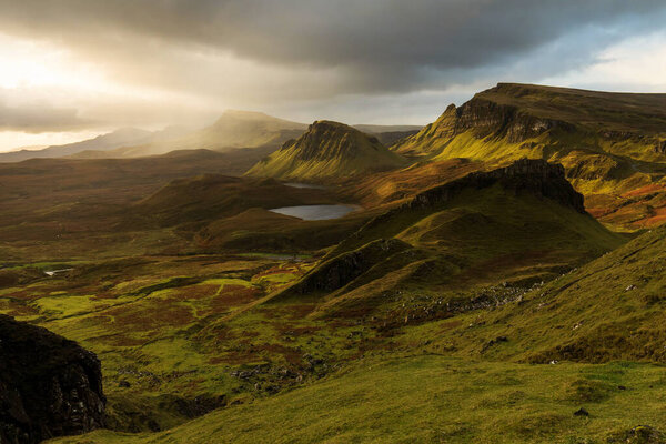 Scenic view of Quiraing mountains in Isle of Skye, Scottish highlands, United Kingdom. Sunrise time with colourful an rayini clouds in backgroun