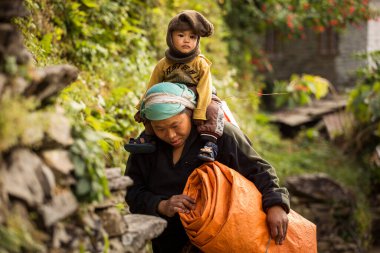 Vilage on trekking, Nepal - 14 Kasım 2017. Çocuk yürüyüş sırasında Nepal 'de geleneksel bir köyde annesinin yanında kalıyor..