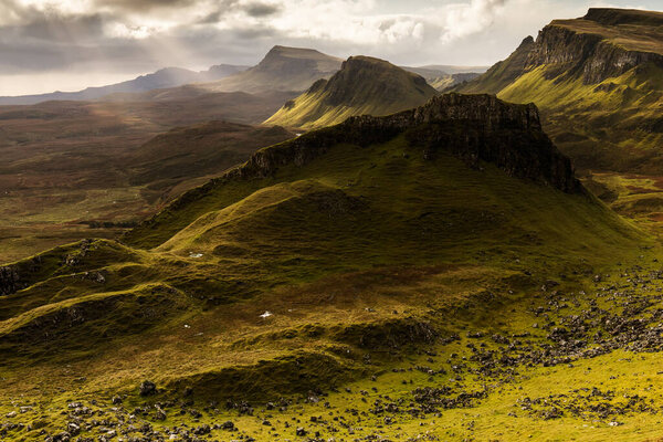 Scenic view of Quiraing mountains in Isle of Skye, Scottish highlands, United Kingdom. Sunrise time with colourful an rayini clouds in backgroun