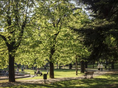 6 Nisan 2017. Bettini Yolu, Rovereto, Trentino, İtalya 'daki Berlasca Bahçesi adlı gezici parkta bahar zamanı insanlar buluşup sohbet eder ve dinlenir.