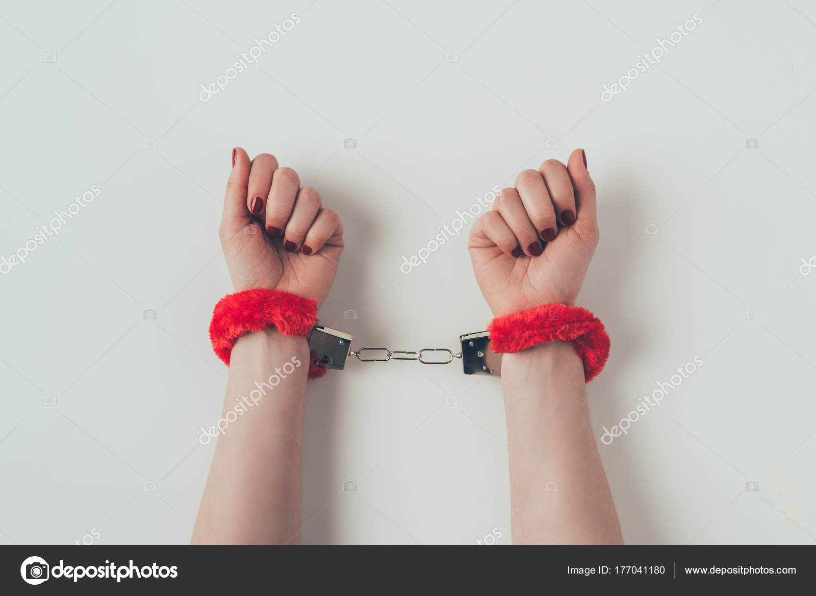 интимная зависимость. держит наручники. мужская и женская рука. связать руку наручники. связанные руки.