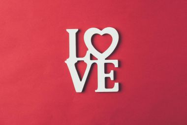 top view of white sign with word love isolated on red clipart