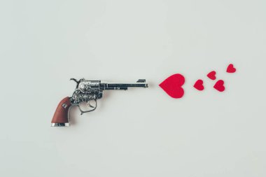 top view of gun aiming at paper hearts isolated on white, valentines day concept clipart