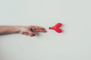 beyaz iki parmak ile sönmüş balon uzanan kadın kırpılmış görüntü, sevgililer günü kavramı